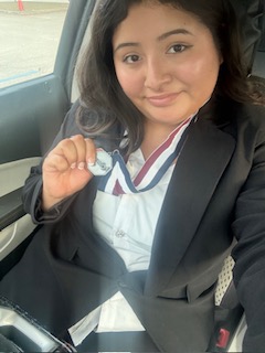 Female student holding medal.